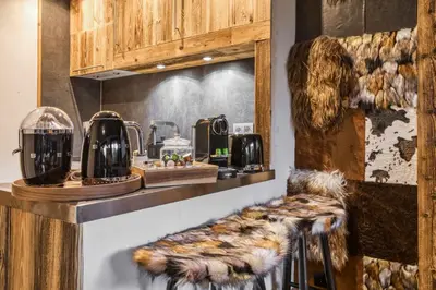 a kitchen with a counter top with a fur stool at Le petit cœur de Megève -Mont770- in Megève