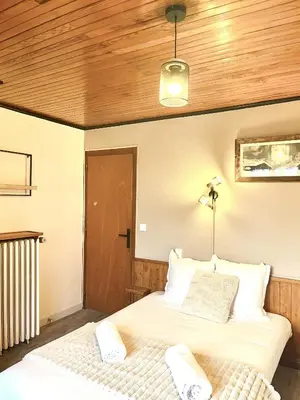 two beds in a bedroom with a wooden ceiling at Le Chaney - T2 dans chalet - Massif du Mont-Blanc in Chamonix-Mont-Blanc