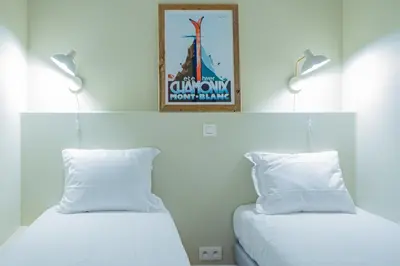 a bedroom with two beds and a poster on the wall at Majestic Alpin - A luxurious apartment with a nordic feel in Chamonix-Mont-Blanc