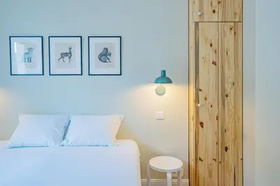a bedroom with a white bed and a wooden cabinet at Majestic Alpin - A luxurious apartment with a nordic feel in Chamonix-Mont-Blanc