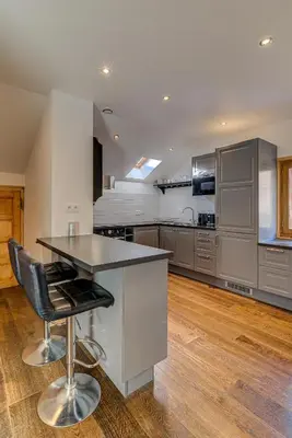 a kitchen with a counter and a table and chairs at Apartment Rebats - Alpes Travel - Central Chamonix in Chamonix-Mont-Blanc