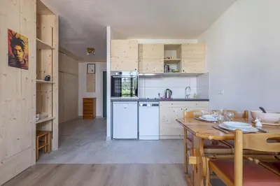 a kitchen with white appliances and a wooden table at Studio a l’aiguille du Midi in Chamonix-Mont-Blanc