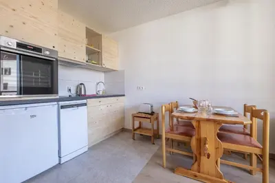 a kitchen with a wooden table and a wooden table and chairs at Studio a l’aiguille du Midi in Chamonix-Mont-Blanc