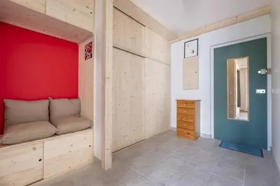 a room with a bench and a red wall at Studio a l’aiguille du Midi in Chamonix-Mont-Blanc