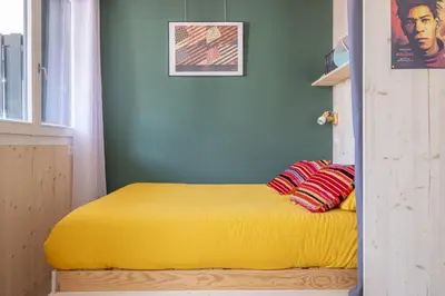 a bed in a room with a yellow blanket at Studio a l’aiguille du Midi in Chamonix-Mont-Blanc
