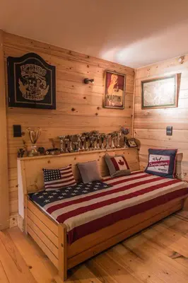 a bed in a room with a wooden wall at Les Mules in Combloux