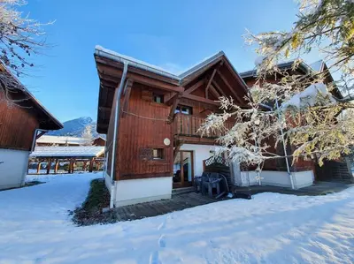 a house with snow on the ground in front of it at Cascades, 3 bedroom chalet with shared pool. in Samoëns