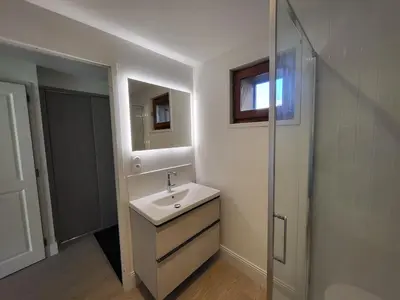 a white bathroom with a sink and a shower at Cascades, 3 bedroom chalet with shared pool. in Samoëns