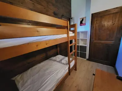 a bedroom with two bunk beds and a closet at Cascades, 3 bedroom chalet with shared pool. in Samoëns