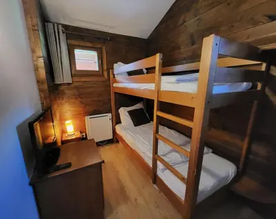 a small room with bunk beds in a cabin at Cascades, 3 bedroom chalet with shared pool. in Samoëns