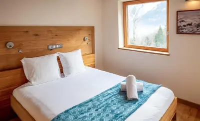 a bedroom with a bed with a teddy bear on it at Les Ecureuils -Rénové 100m2 - 8per - Skis aux Pieds - Vue sur la Montagne in Les Houches
