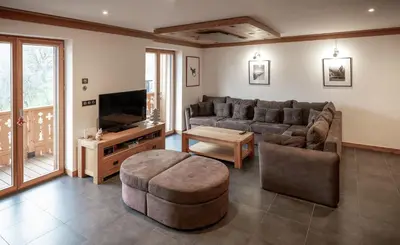 a living room with a couch and a tv at Les Ecureuils -Rénové 100m2 - 8per - Skis aux Pieds - Vue sur la Montagne in Les Houches