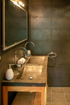 a bathroom sink with two faucets and a mirror at Les Ecureuils -Rénové 100m2 - 8per - Skis aux Pieds - Vue sur la Montagne in Les Houches