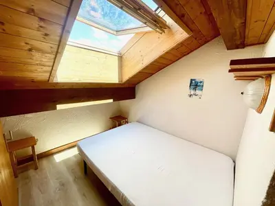 a bedroom with a large bed with a skylight at T3 Appartement haute-Savoie Carroz in Les Carroz d'Araches