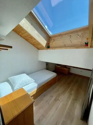 a small bedroom with a bed and a skylight at T3 Appartement haute-Savoie Carroz in Les Carroz d'Araches
