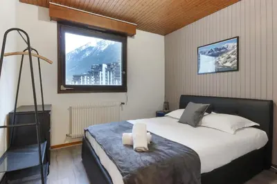 a bedroom with a large bed and a window at L'Aiguille - Center of Chamonix - View Mont-Blanc in Chamonix-Mont-Blanc