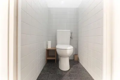 a white toilet in a bathroom with white tiles at L'Aiguille - Center of Chamonix - View Mont-Blanc in Chamonix-Mont-Blanc