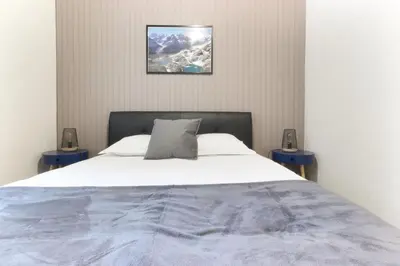 a bedroom with a large bed with two night stands at L'Aiguille - Center of Chamonix - View Mont-Blanc in Chamonix-Mont-Blanc