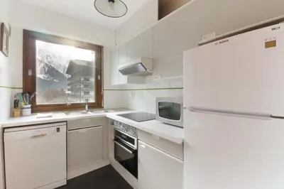 a white kitchen with a refrigerator and a microwave at Makalu - View Mont-Blanc - Chamonix Center -8 pers in Chamonix-Mont-Blanc
