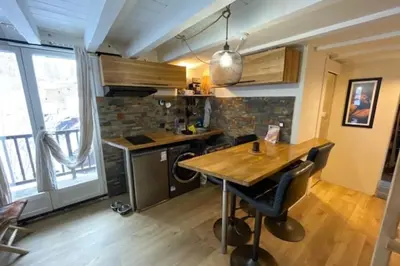 a kitchen with a wooden table and a large window at Apt with nice view near the center of Chamonix in Chamonix-Mont-Blanc