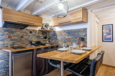 a kitchen with a wooden table and chairs at Apt with nice view near the center of Chamonix in Chamonix-Mont-Blanc