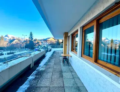 a bench sitting on a sidewalk next to a building at White Lodges - Megève center on ski slopes in Megève