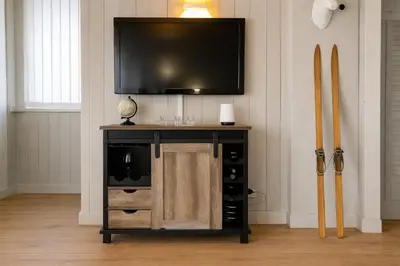 a entertainment center with a flat screen tv on a wall at White Lodges - Megève center on ski slopes in Megève
