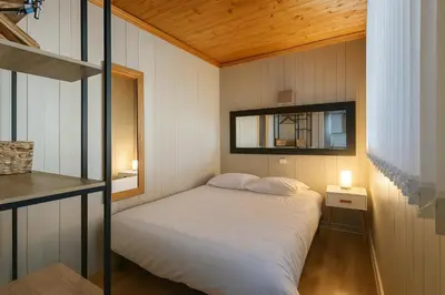 a small bedroom with a bed and a mirror at White Lodges - Megève center on ski slopes in Megève