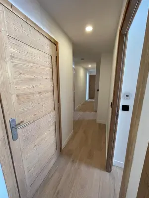 a hallway with a wooden door and a hallway leading into a room at les Airelles 202 in Les Carroz d'Araches