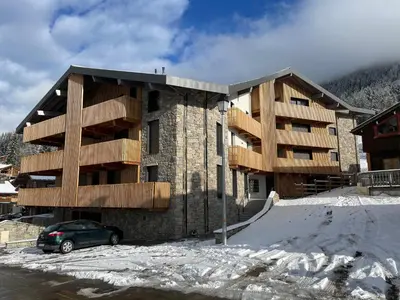 a building with a car parked in front of it at les Airelles 202 in Les Carroz d'Araches