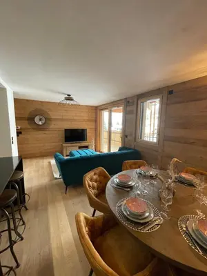 a living room with a table and a blue couch at les Airelles 202 in Les Carroz d'Araches