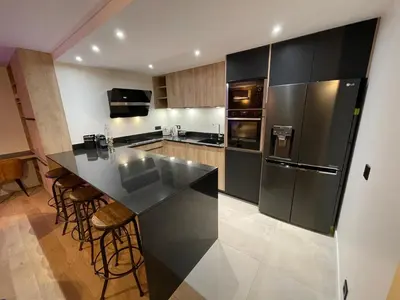 a kitchen with a black counter and a refrigerator at les Airelles 202 in Les Carroz d'Araches