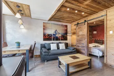a living room with a couch and a table at Le Nid d'Aigle - Modern Apartment Next to Ski lift Prarion - By Cozee Rentals in Les Houches