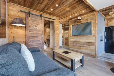 a living room with a couch and a flat screen tv at Le Nid d'Aigle - Modern Apartment Next to Ski lift Prarion - By Cozee Rentals in Les Houches