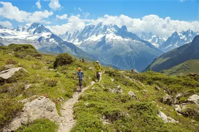two people walking on a trail in the mountains at Le Nid d'Aigle - Modern Apartment Next to Ski lift Prarion - By Cozee Rentals in Les Houches
