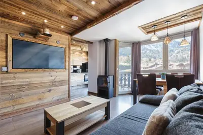 a living room with a couch and a tv at Le Nid d'Aigle - Modern Apartment Next to Ski lift Prarion - By Cozee Rentals in Les Houches