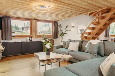 a living room with a couch and a table at Chalet Isabella by Brennus Chamonix in Chamonix-Mont-Blanc