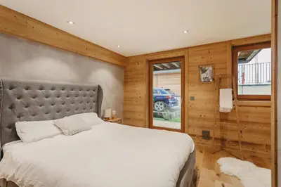 a bedroom with a large bed and wooden walls at Chalet Isabella by Brennus Chamonix in Chamonix-Mont-Blanc