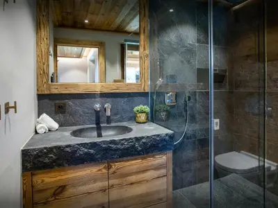 a bathroom with a sink and a glass shower at Chalet Beau Caillou - OVO Network in Saint-Gervais-les-Bains