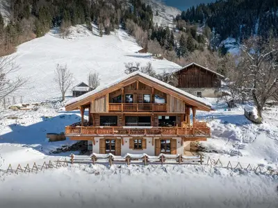 a large wooden house in the snow with snow at Chalet Beau Caillou - OVO Network in Saint-Gervais-les-Bains