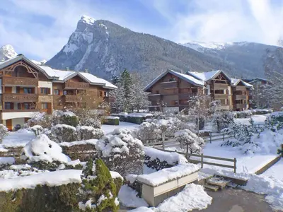 a lodge in the snow with a mountain in the background at Studio confortable à Samoëns avec parking et animaux acceptés - FR-1-629-118 in Samoëns