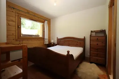 a bedroom with a wooden bed and a window at Résidence Le Hameau Des Glaciers - Hameau des Glaciers D02 MAE-5834 in Les Houches