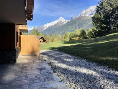 a driveway leading to a house with mountains in the background at Résidence Le Hameau Des Glaciers - Hameau des Glaciers D02 MAE-5834 in Les Houches