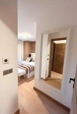 a bedroom with a mirror and a bed in a room at Les Chamois D’Arbois, Mont D’Arbois, Megève in Megève