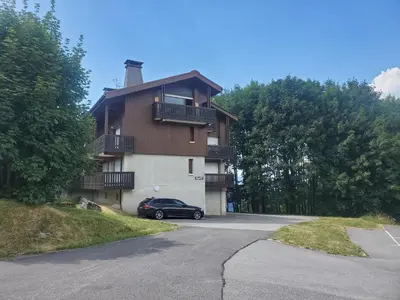 a building with a car parked in front of it at Studio avec petit balcon et cheminée - Grand Massif in Les Carroz d'Araches