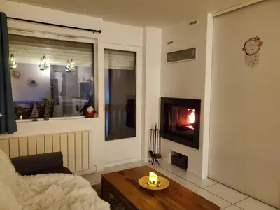 a living room with a fire in the fireplace at Studio avec petit balcon et cheminée - Grand Massif in Les Carroz d'Araches