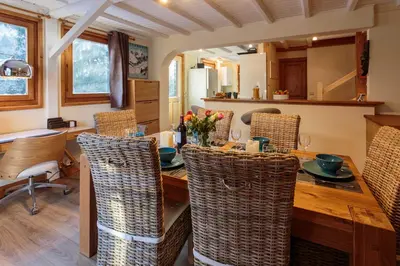 a dining room with a table and wicker chairs at Chalet des Favrands in Chamonix-Mont-Blanc