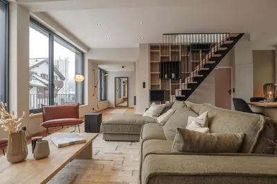 a living room with a couch and a staircase at Appartement Rooftop Chamonix in Chamonix-Mont-Blanc