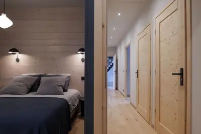 a bedroom with a bed and a wooden wall at Appartement Rooftop Chamonix in Chamonix-Mont-Blanc