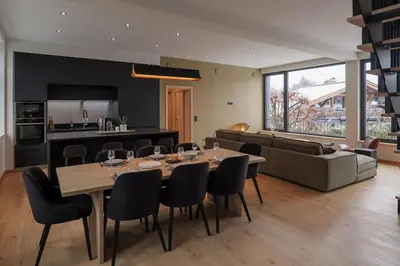 a dining room and living room with a table and chairs at Appartement Rooftop Chamonix in Chamonix-Mont-Blanc